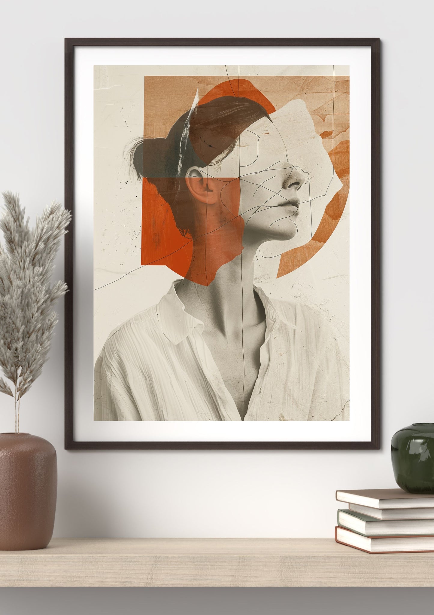 Framed modern abstract portrait in black frame hanging on wall above stacked books and ceramic decor.