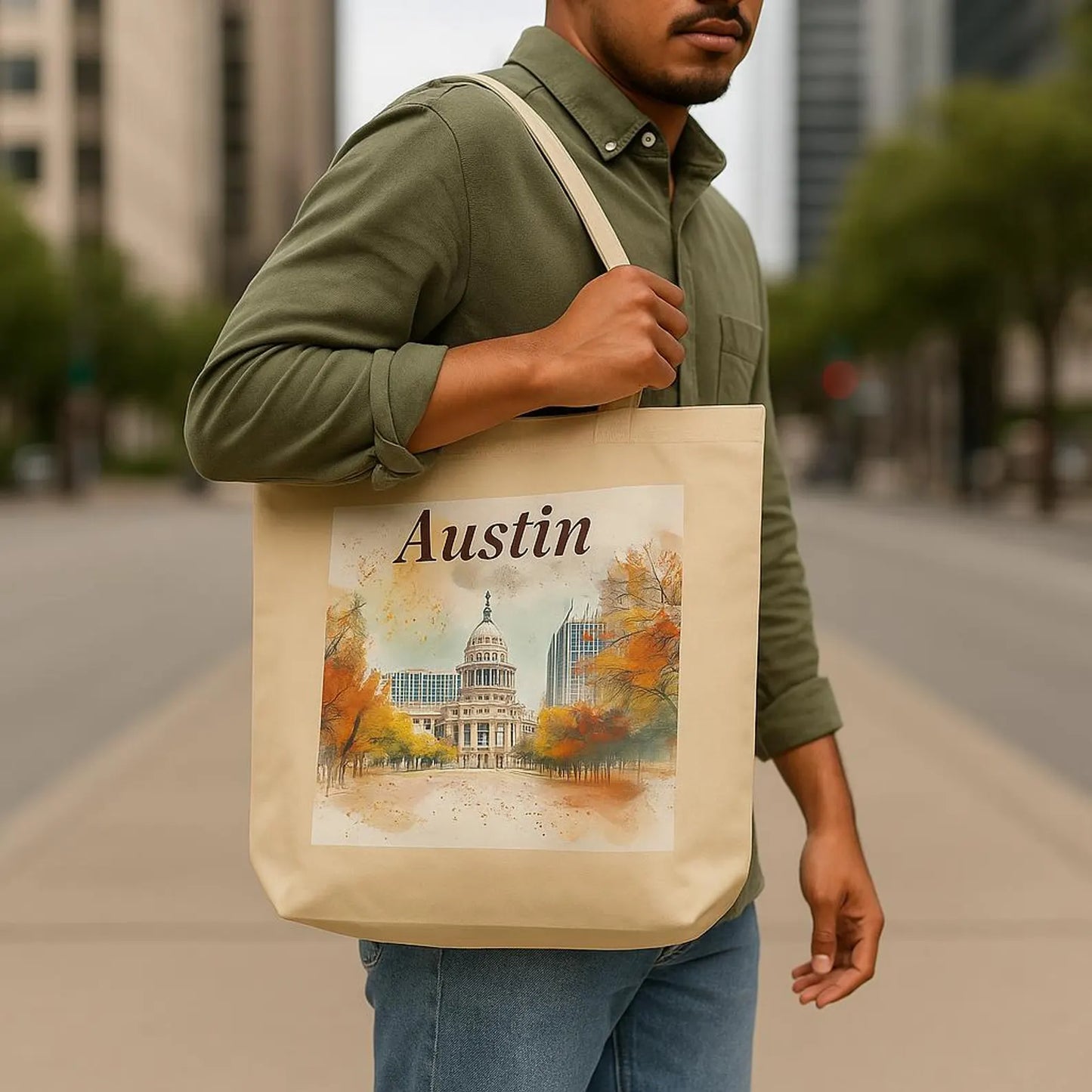 Young man in casual green shirt and jeans holding Austin city tote on shoulder, standing on city sidewalk with trees in the background
