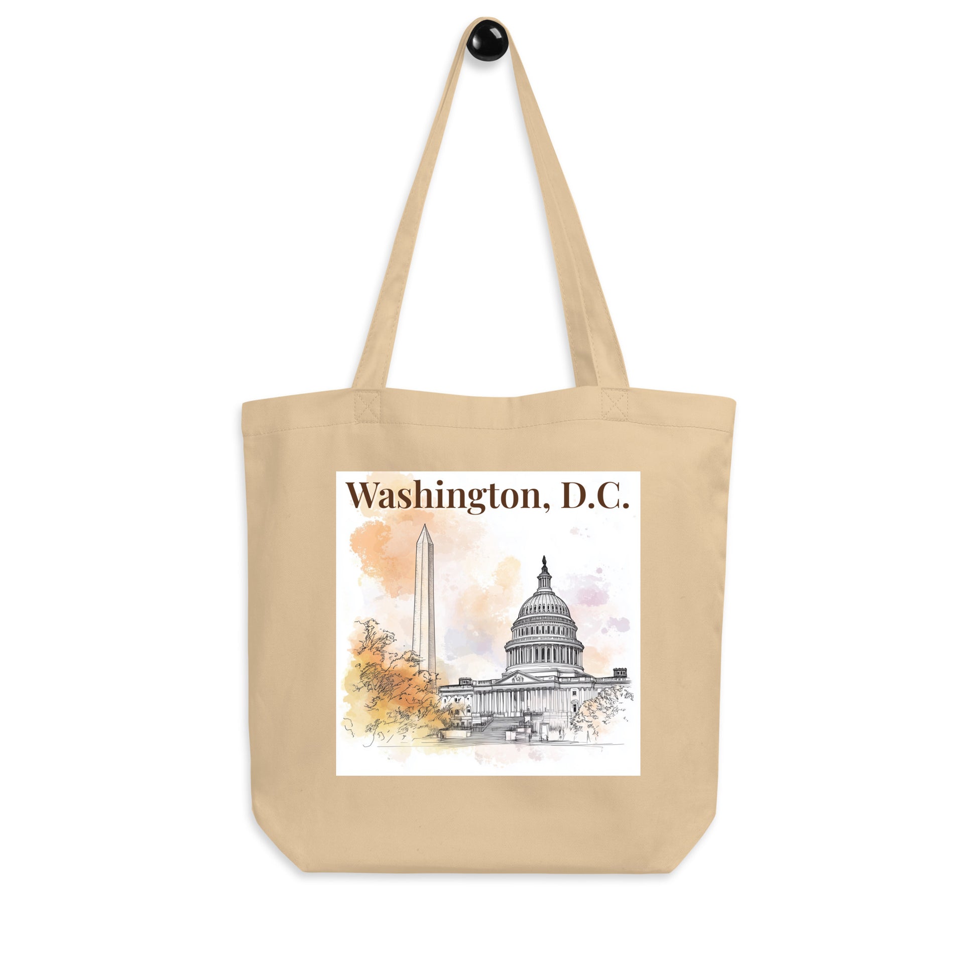 Straight-on product shot of the beige tote bag with Washington, D.C. watercolor print featuring iconic architecture. Simple background for clean presentation.