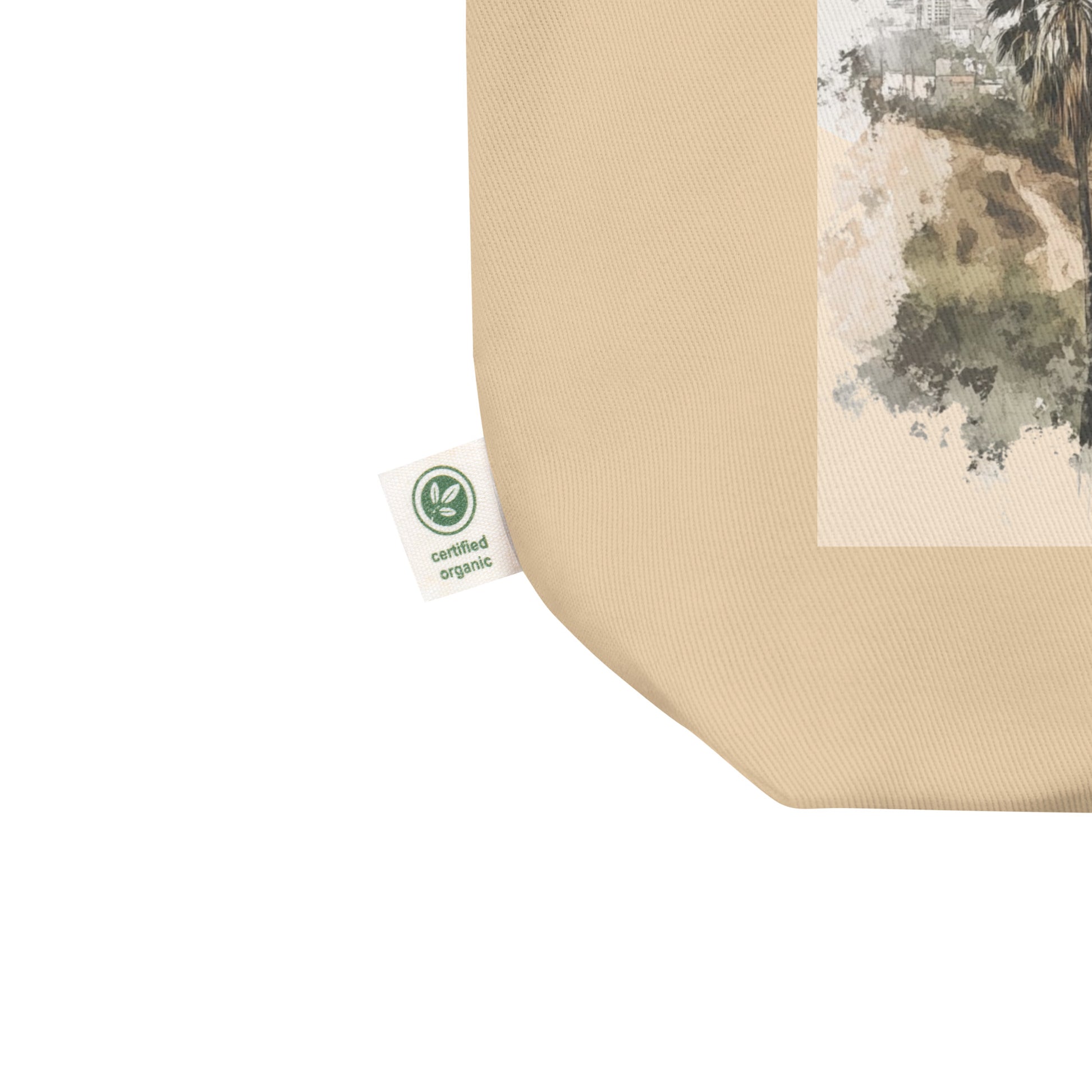 Close-up of Los Angeles tote bag corner with certified organic cotton tag visible, beige fabric texture
