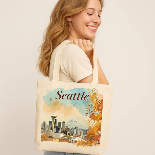 Smiling woman holding a beige tote bag with a watercolor Seattle print, neutral soft background.