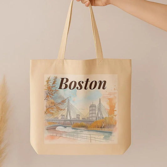 Hand holding beige Boston tote bag with artistic cityscape print, neutral background, minimalist eco-friendly style.